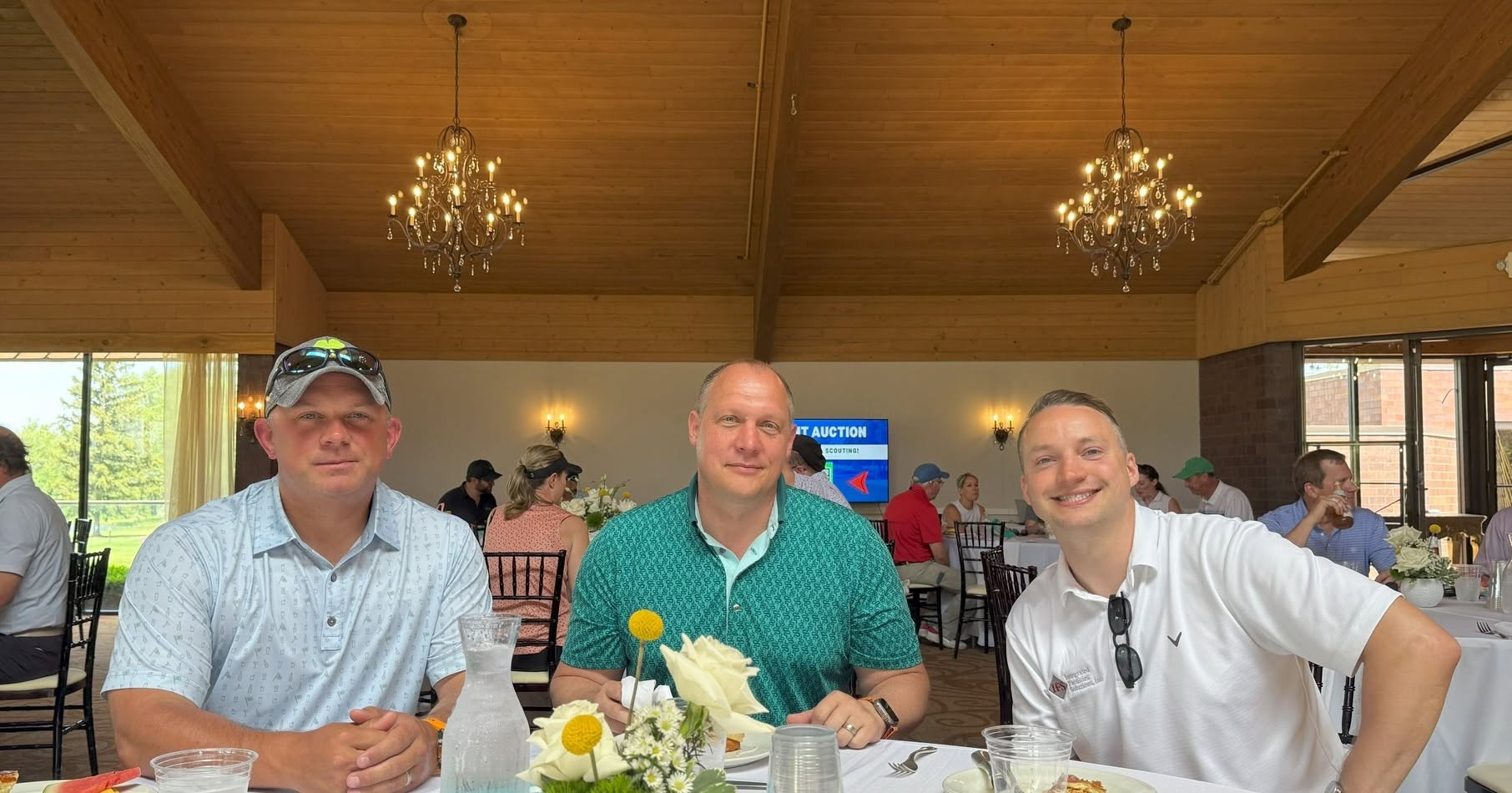 Three men sit at a fancy table inside a restaurant
