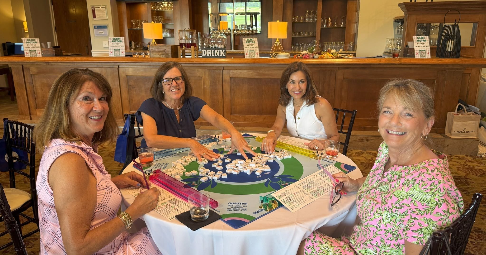 Women sit around a circular table playing a board game